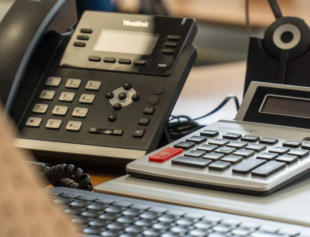 Telefoon en rekenmachine op een bureau bij IZI!