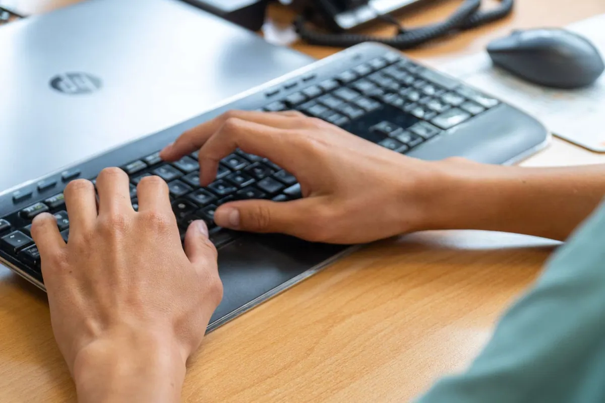 Handen op het toetsenbord van een laptop bij IZI!
