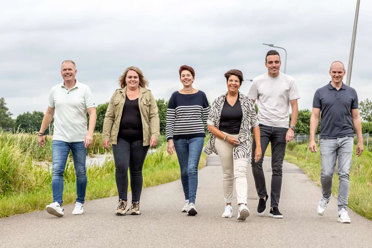 Het team van IZI! wandelt samen over een polderweg